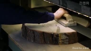 细木工用木材砂光机磨平原木片，木匠用固定的电动带砂光机磨平原木片